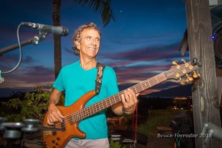 Barney Cortinez playing bass at sunset on Maui.